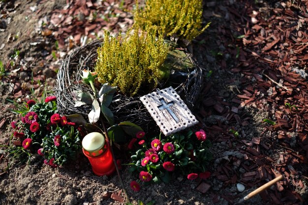 Hooghoekbeeld van kruis en bloemen op de begraafplaats