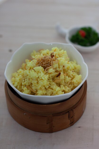 Hooghoekbeeld van kurkuma rijst in een kom op tafel Indonesische traditionele rijstgerecht