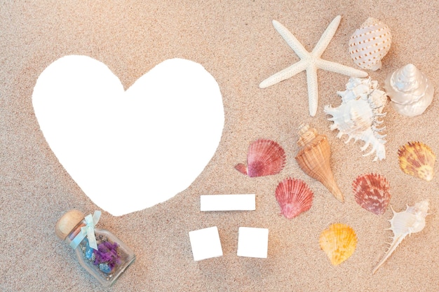 Foto hooghoekbeeld van leeg hartvormig papier en zeeschelpen op zand op het strand