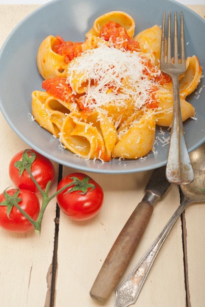 Hooghoekbeeld van lumaconi pasta geserveerd in een bord op tafel