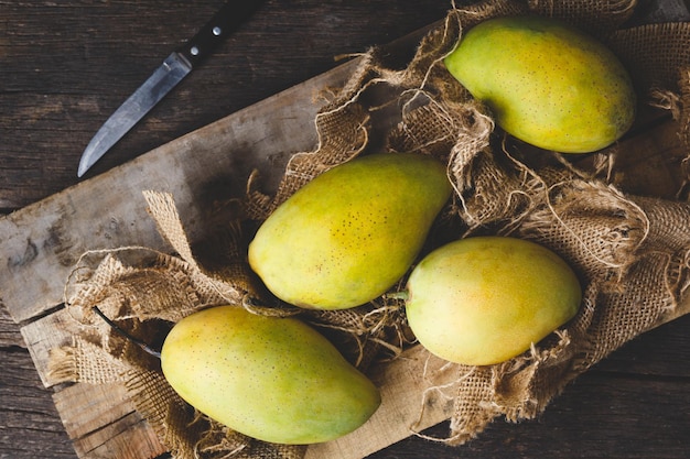 Hooghoekbeeld van mango's op de snijplank boven de tafel