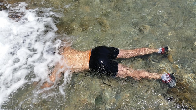 Foto hooghoekbeeld van mannen die in het water liggen