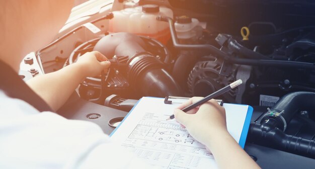 Hooghoekbeeld van mechanisch schrijven op papier in een auto-reparatiewerkplaats