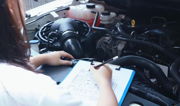 Hooghoekbeeld van mechanisch schrijven op papier in een auto-reparatiewerkplaats