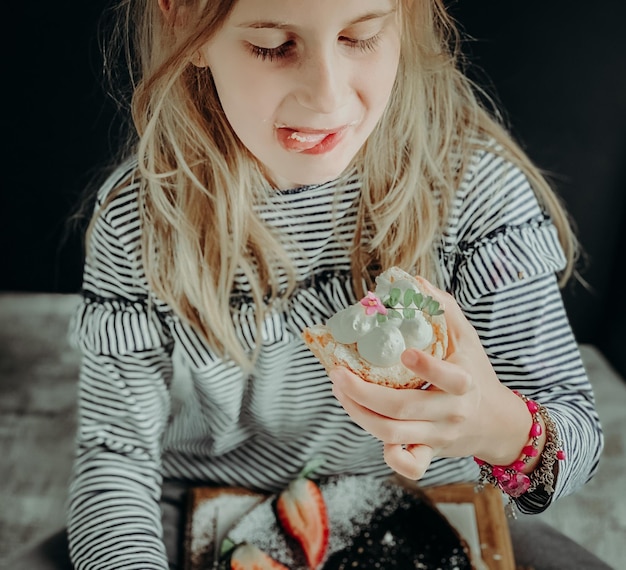 Foto hooghoekbeeld van meisje dat thuis dessert vasthoudt