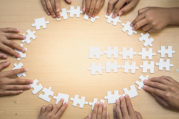 Foto hooghoekbeeld van mensen die puzzelstukjes op tafel houden