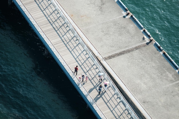 Foto hooghoekbeeld van mensen op de pier over de zee