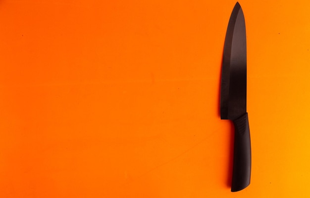 Hooghoekbeeld van mes tegen oranje achtergrond