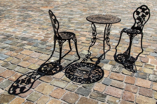 Foto hooghoekbeeld van metalen stoelen en tafel op het voetpad