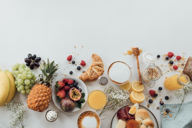 Hooghoekbeeld van ontbijt op tafel tegen een witte achtergrond