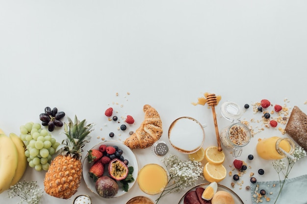 Hooghoekbeeld van ontbijt op tafel tegen een witte achtergrond