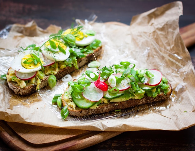 Hooghoekbeeld van open sandwiches op waspapier