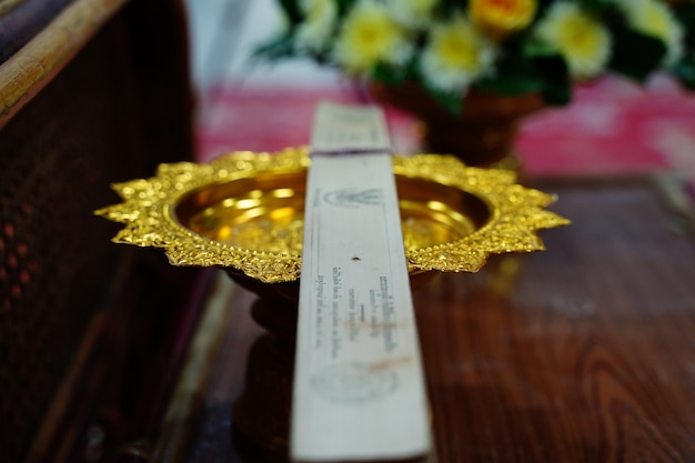 Foto hooghoekbeeld van papier op gouden container aan tafel in de tempel