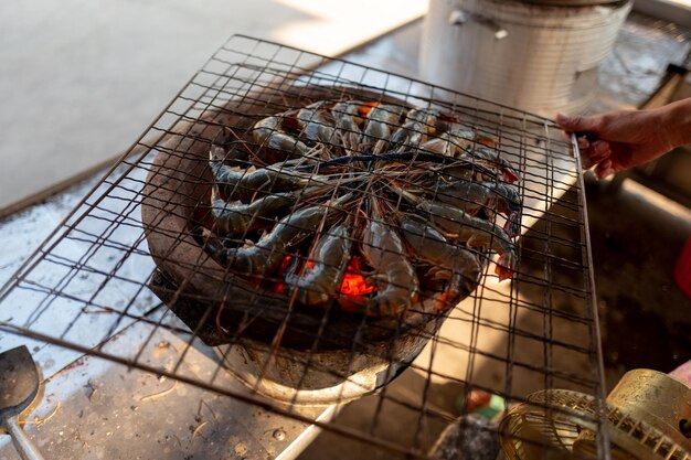 Foto hooghoekbeeld van persoon die eten bereidt op barbecue grill