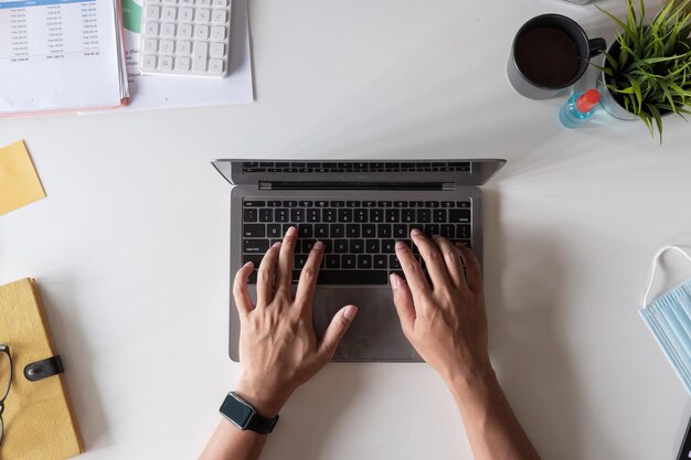 Foto hooghoekbeeld van persoon die laptop op tafel gebruikt