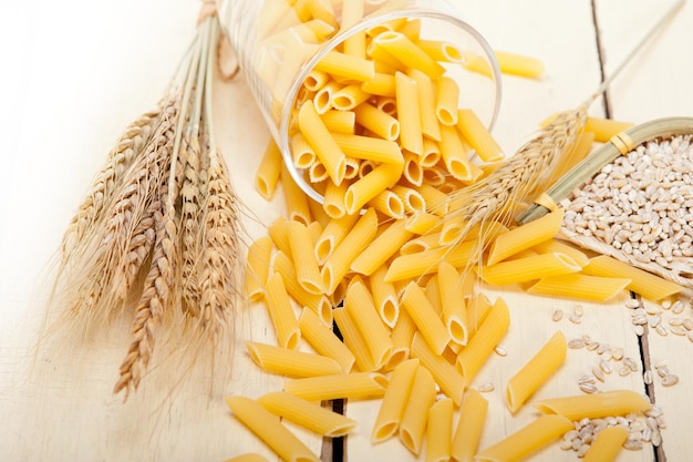 Hooghoekbeeld van rauwe pasta met tarwe op tafel