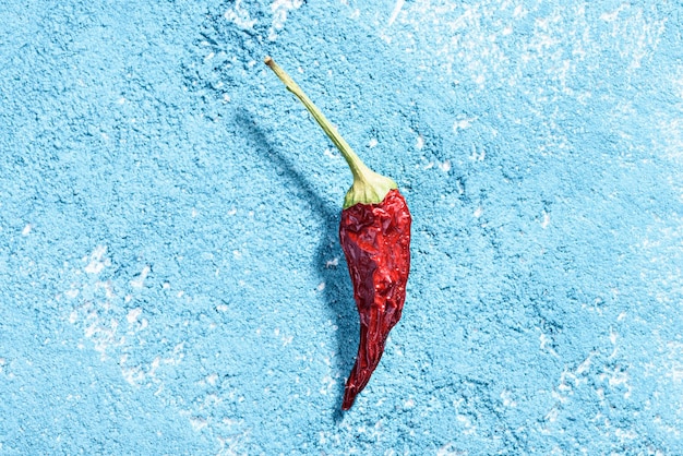 Foto hooghoekbeeld van rode chili peper op blauw oppervlak