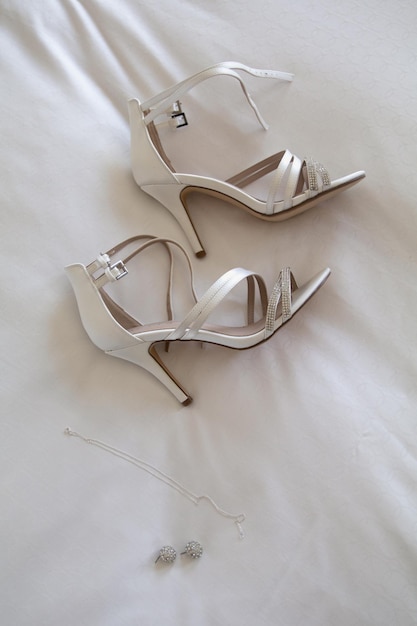 Hooghoekbeeld van schoenen op een wit bed
