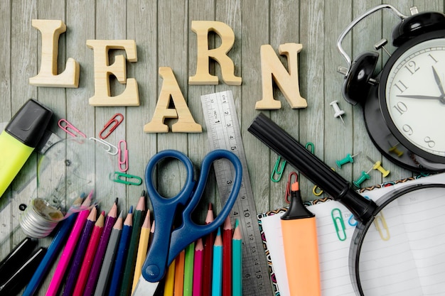 Hooghoekbeeld van schoolbenodigdheden door leertekst op tafel