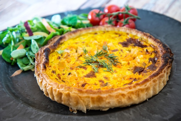 Foto hooghoekbeeld van taart met tomaten en salade op tafel