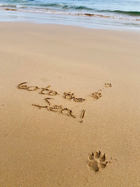 Foto hooghoekbeeld van tekst op zand op het strand