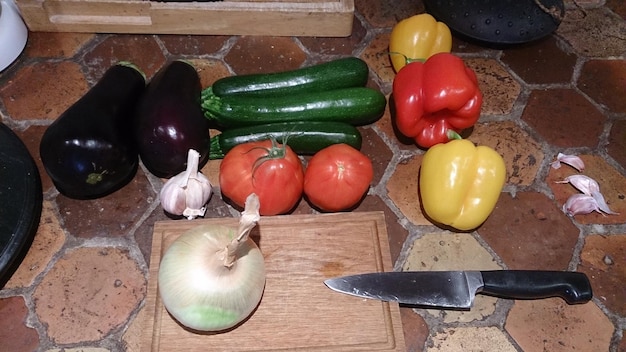 Foto hooghoekbeeld van uien met capsicum en aubergines op de vloer