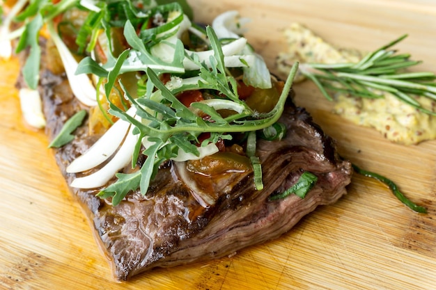 Foto hooghoekbeeld van vers rundvlees met arugula op de snijplank