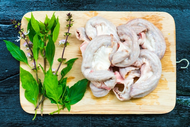 Hooghoekbeeld van vlees en kruiden op de snijplank boven de tafel