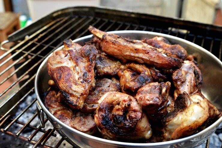 Foto hooghoekbeeld van vlees in een kookpan op een barbecue grill