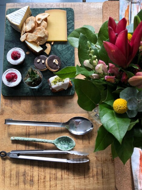 Foto hooghoekbeeld van voedsel en bloemen met keukentoestellen op tafel