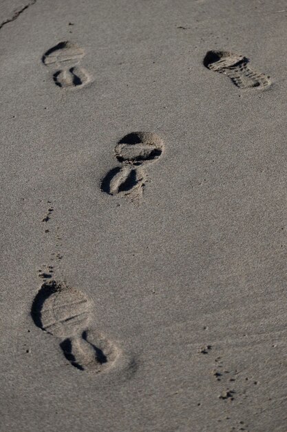 Hooghoekbeeld van voetafdrukken op het zand op het strand