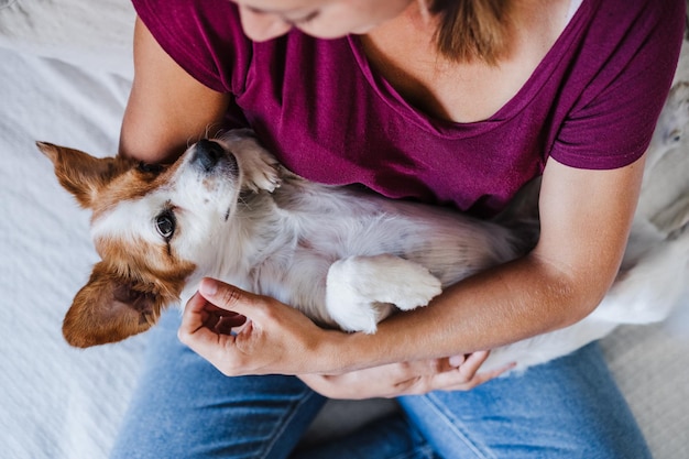 Hooghoekbeeld van vrouw met hond die op bed zit
