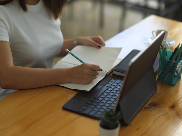 Hooghoekbeeld van vrouw met laptop op tafel