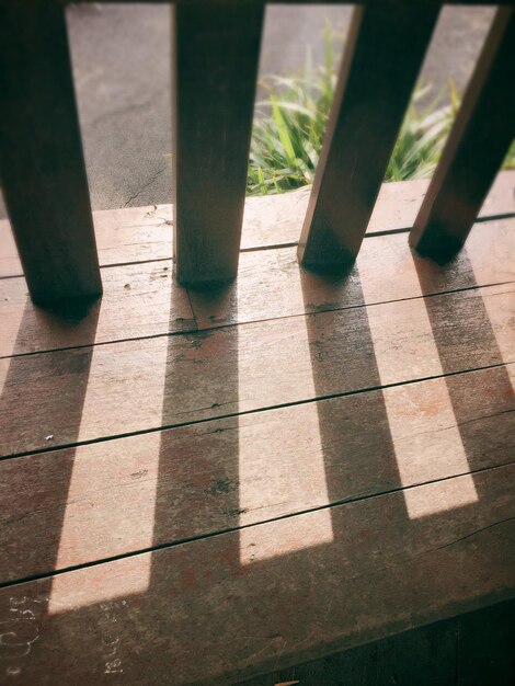 Foto hooghoekbeeld van zonlicht dat door een reling op houten planken valt