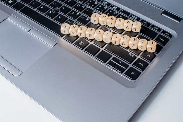 Foto hooghoekige weergave van alfabetten in houten blokken op het toetsenbord van een laptop