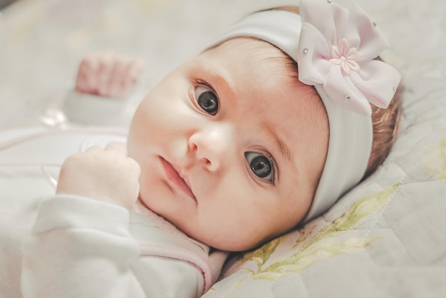 Hooghoekportret van een schattig baby meisje dat thuis op bed ligt
