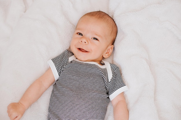 Hooghoekportret van een schattige baby die op het bed ligt