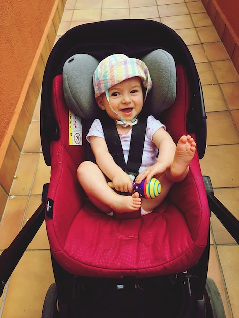 Foto hooghoekportret van een vrolijke baby in een wagen