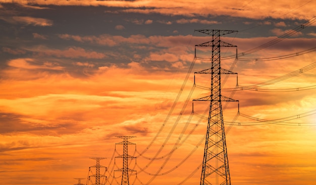 Hoogspannings elektrische paal en transmissielijn in de avond