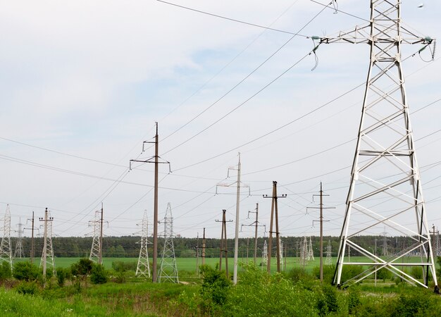 Hoogspanningsleidingen van metaal en beton tegen de hemel