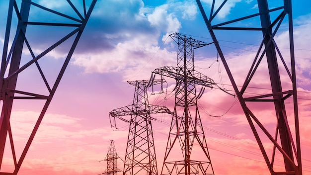 Hoogspanningslijnen leveren met draad hoogspanning elektrische toren met isolatoren bij zonsopgang