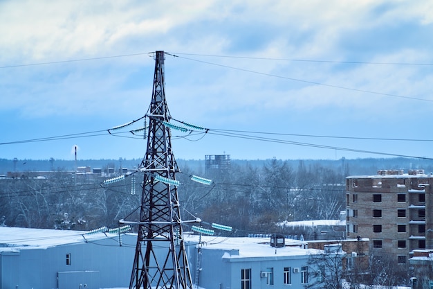 Hoogspanningslijntoren met sneeuw bedekte hoogspanningsisolatoren. wintertijd