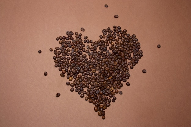 Hoogste die meningshart van koffiebonen wordt gemaakt op een bruine achtergrond