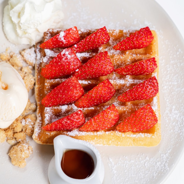 Hoogste hoekmening van de wafel van de close-upaardbei met honing voor bovenste laagje