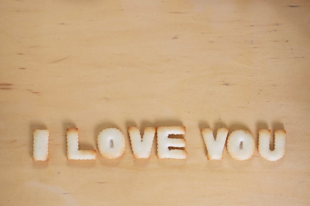 Hoogste mening van brievencollage die van koekjes wordt gemaakt. word i love you op houten tafel