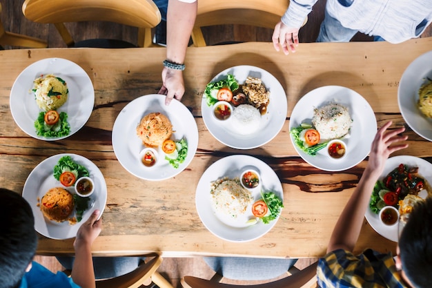 Hoogste mening van mensen die diner hebben samen op houten lijst