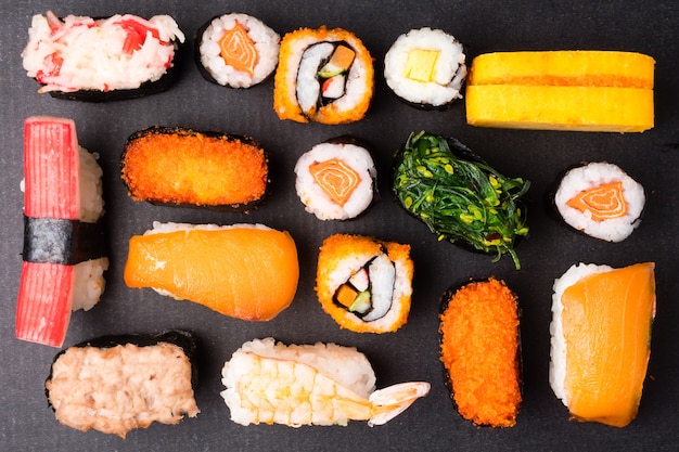 Hoogste mening van Sushi die op zwarte achtergrond, Japans voedsel worden geplaatst.