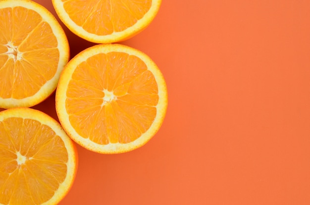 Hoogste mening van verscheidene oranje fruitplakken op heldere achtergrond in oranje kleur.