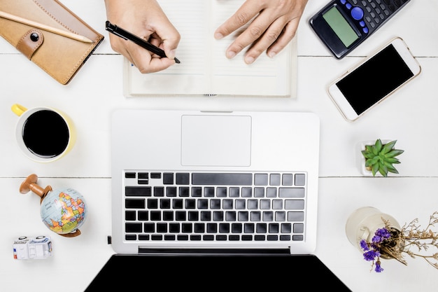 Hoogste mening van wit bureau met laptop en koffiekop