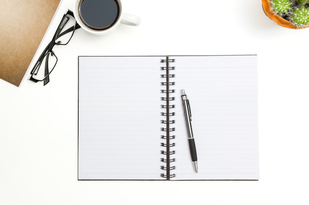 Hoogste menings lege notitieboekje, pen en glazen op witte bureauachtergrond